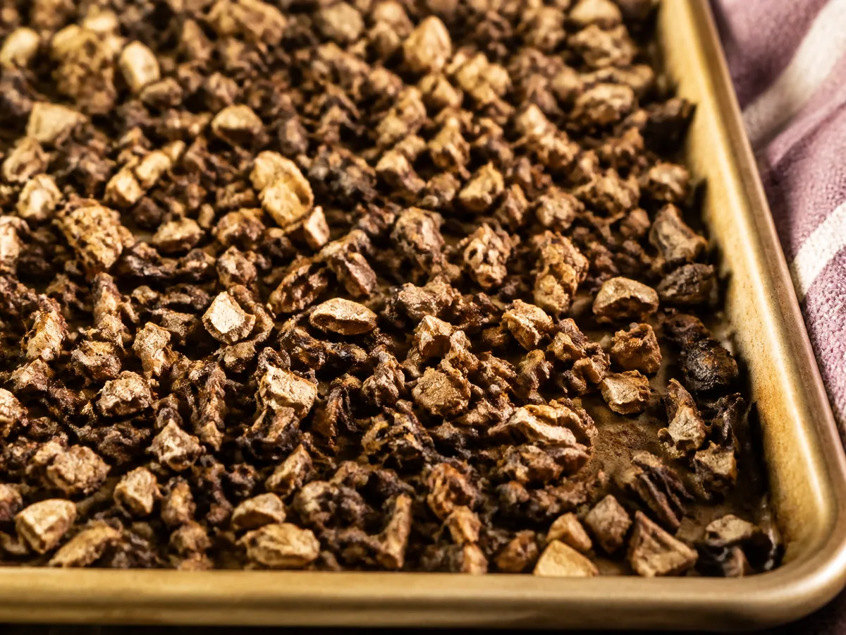 Browned chopped cremini spread in a thin dry layer on a tray
