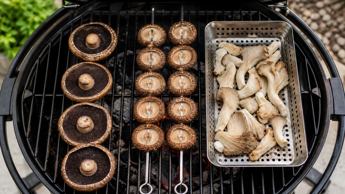 Portobello caps on bare grates, shiitake caps on skewers, and oyster mushrooms in a grill basket