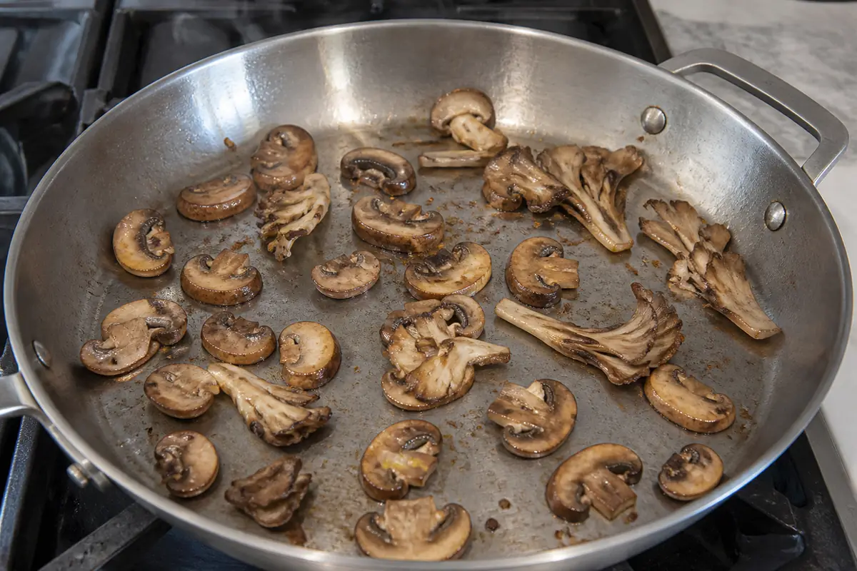 Mushroom pieces browning in one uncrowded layer in a broad skillet