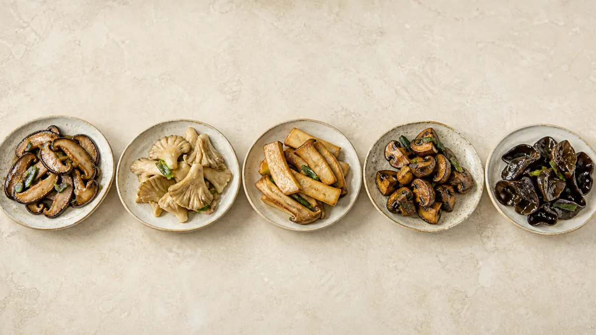 Five finished stir-fry portions showing shiitake, oyster, king oyster, cremini, and wood ear