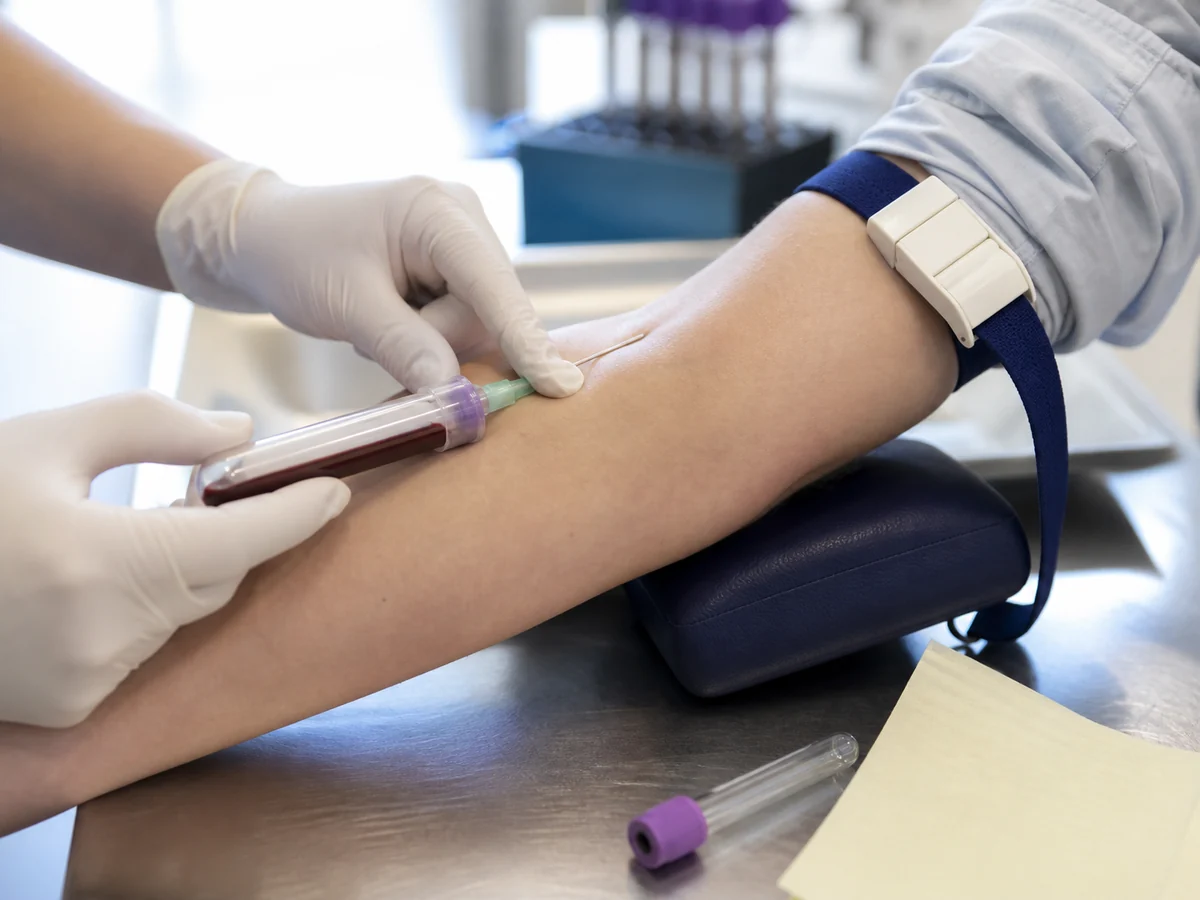 Blood sample being drawn into a collection tube for a lipid panel in a clinic