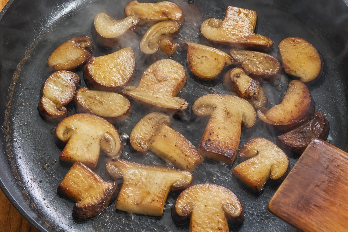 Even bay bolete slices releasing moisture under sustained heat in an uncrowded skillet - cooking bay bolete during pregnancy