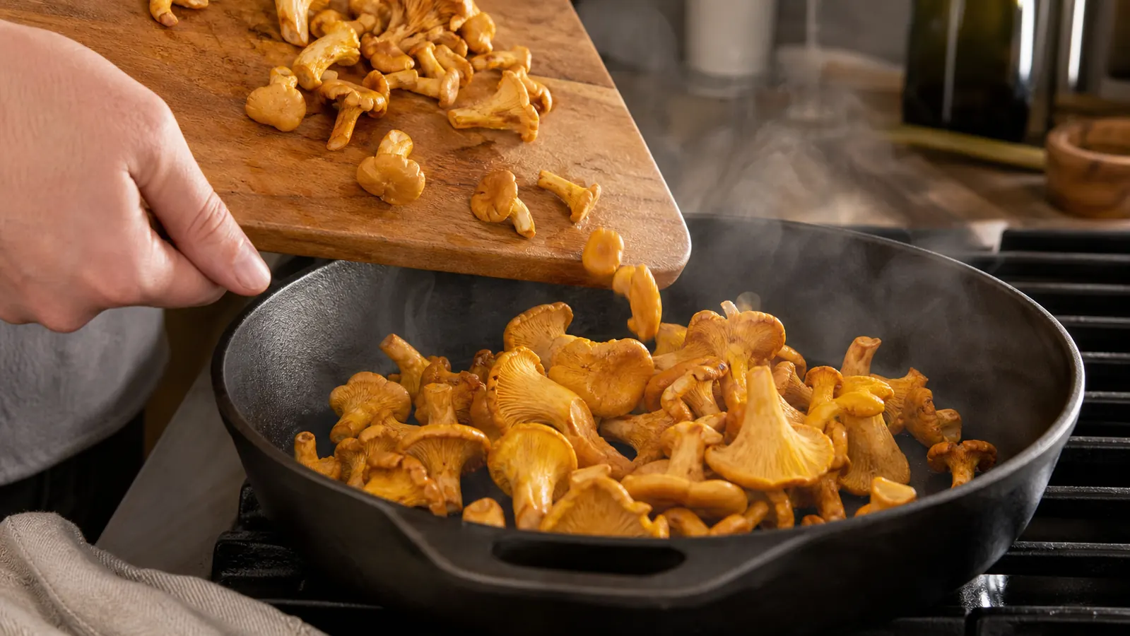 Golden chanterelles moving from a cutting board into a hot skillet