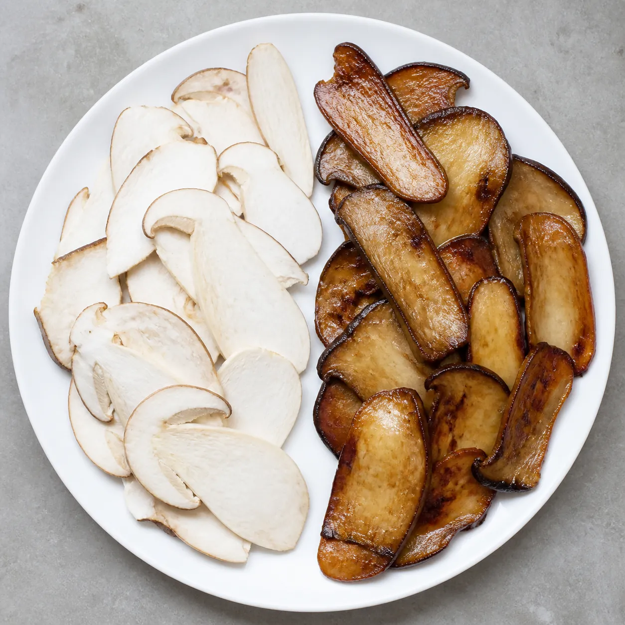 A plain plate split between pale translucent raw porcini slices and deeply browned sauteed slices