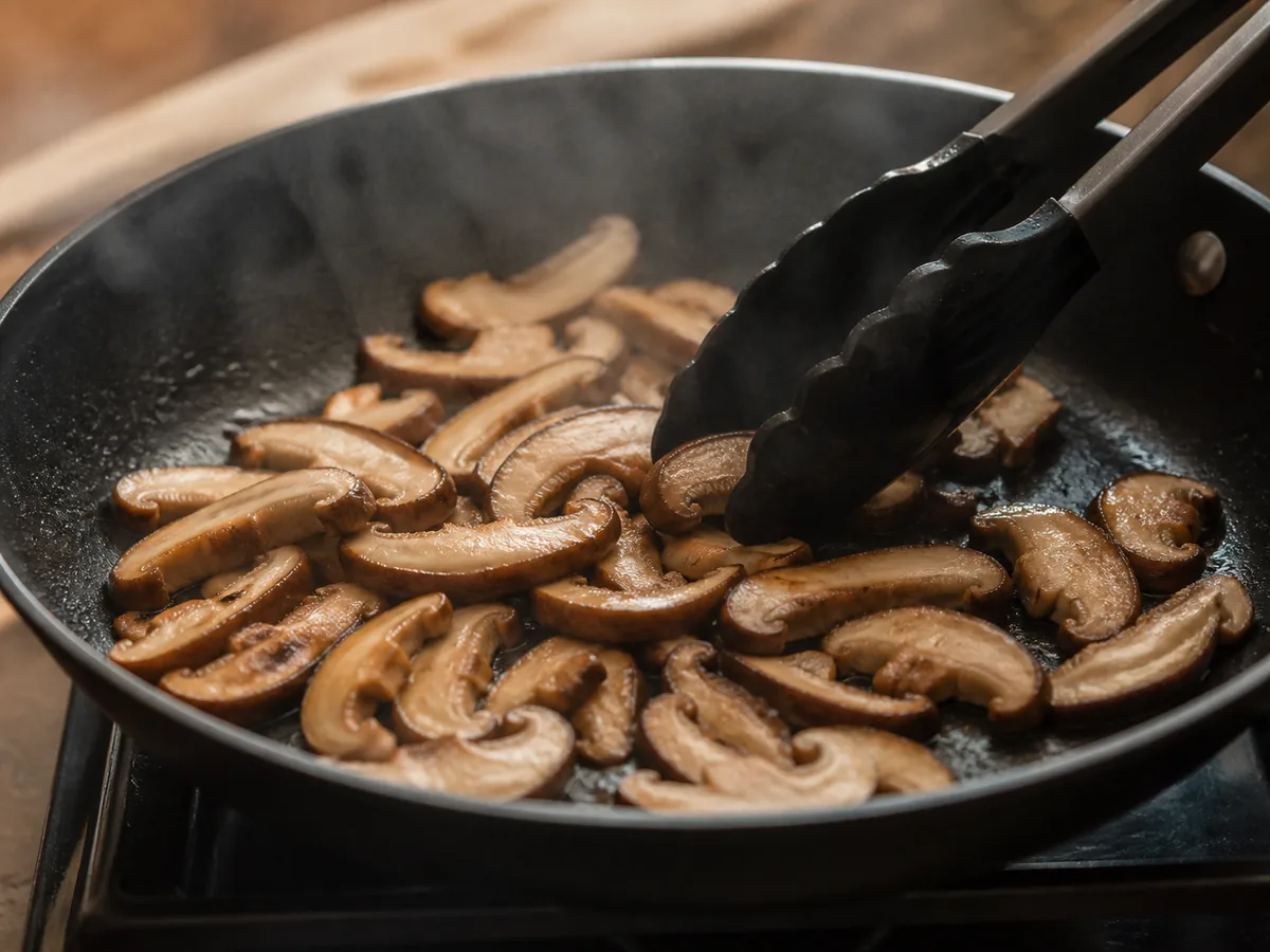 Even shiitake slices cooking in one layer with steam in a broad skillet - cooking shiitake during pregnancy