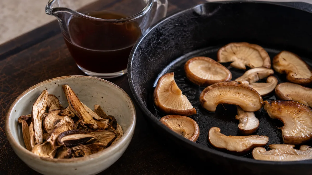 Porcini and shiitake mushrooms beside a pot of mushroom stock - morel substitute